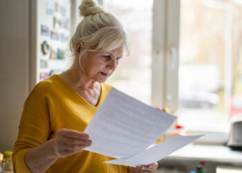 Senior woman filling out financial statements