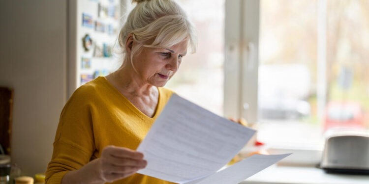 Senior woman filling out financial statements