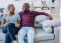 Young african american marriage having discussion about problem sitting at couch in living room, romantic couple talking about relationship looking at each other spending time together at living room ; Shutterstock ID 1231160968; Purchase Order: 20076173