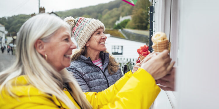 A shot of two mature women getting ice-creams from an ice cream parlor in Cornwall.